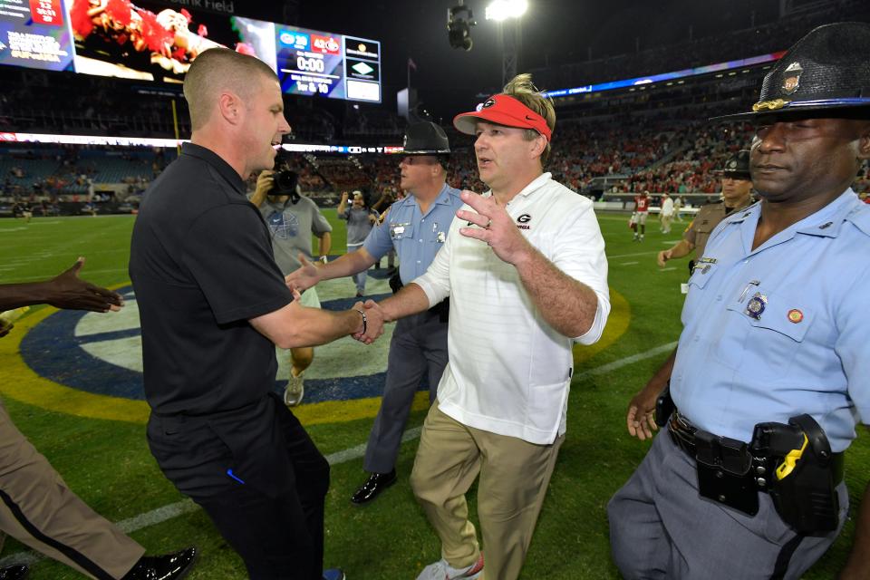 Florida football coach Billy Napier (L), seen here shaking hands with Georgia coach Kirby Smart after last year's 42-20 Bulldogs' win, can put his program on the national radar if the Gators can shock the college football world and upset two-touchdown favorite Georgia at EverBank Stadium on Saturday.