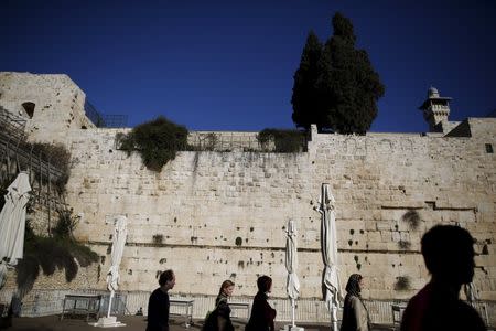 Tourists walk by part of the Western Wall, following the Israeli government's approval to create a mixed-sex prayer plaza near Jerusalem's Western Wall to accommodate Jews who contest Orthodox curbs on worship by women at the site, in Jerusalem's Old City January 31, 2016. REUTERS/Amir Cohen