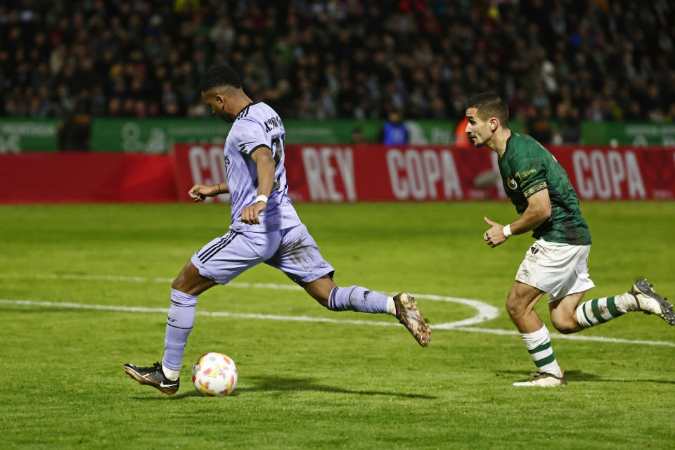 Real Madrid's Rodrygo, left, shoots to scores the opening goal during a Spanish Copa del Rey round of 32 soccer match between Cacereno and Real Madrid at the Principe Felipe stadium in Caceres, Spain, Tuesday Jan. 3, 2023. (AP Photo/Pablo Garcia)