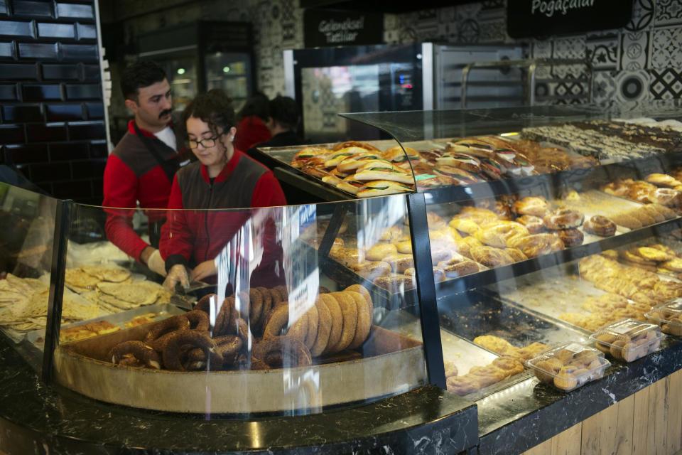 Two young people work at a traditional bakery in Ankara, Turkey, Monday, Dec. 5, 2022. Annual inflation in Turkey slightly eased in November for the first time in more than a year, according to official figures released on Monday, although it remains close to 24-year highs. (AP Photo/Burhan Ozbilici)