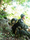 In this photo provided by Karen National Liberation Army, soldiers of the Karen National Liberation Army are seated in a forest Friday, May 7, 2021, in Mutraw district, Karen State, Myanmar. Ethnic Karen guerrillas burned down a Myanmar military outpost Friday morning, capturing it without a fight after its garrison fled at their approach, a senior Karen officer said. (Karen National Liberation Army via AP)