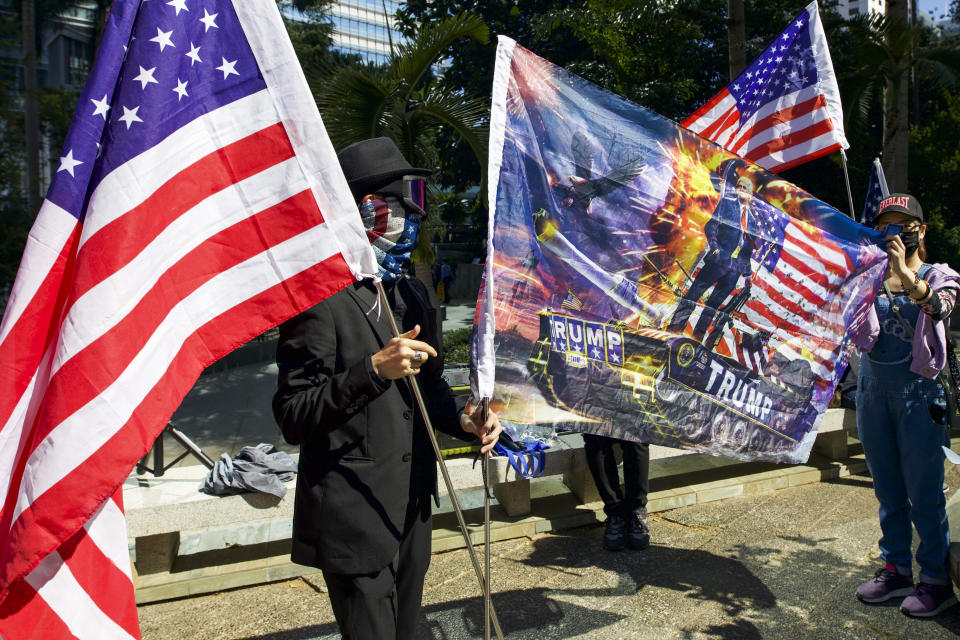 Protesters hold American flags during a rally in Hong Kong, Sunday, Dec. 1, 2019. China accused the U.N. high commissioner for human rights of emboldening "radical violence" in Hong Kong by suggesting the city's leader conduct an investigation into reports of excessive use of force by police. The back and forth came ahead of three marches on Sunday in the semi-autonomous Chinese territory. (AP Photo/Ng Han Guan)