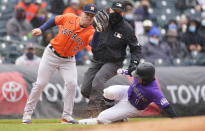 Houston Astros third baseman Alex Bregman, left, fields the throw as Colorado Rockies' Garrett Hampson steals third base in the second inning of a baseball game Wednesday, April 21, 2021, in Denver. (AP Photo/David Zalubowski)