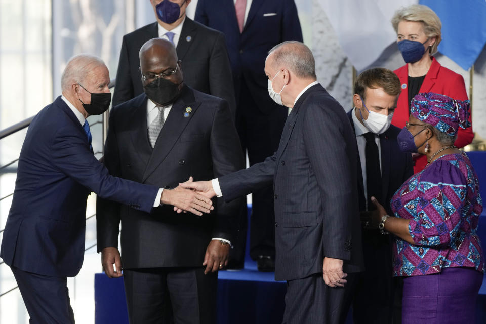 U.S. President Joe Biden, left, greets Turkey's President Recep Tayyip Erdogan, center, as French President Emmanuel Macron, second right, talks to World Trade Organization President Ngozi Okonjo-Iweala, far right, during a group photo of world leaders at the La Nuvola conference center for the G20 summit in Rome, Saturday, Oct. 30, 2021. The two-day Group of 20 summit is the first in-person gathering of leaders of the world's biggest economies since the COVID-19 pandemic started. (AP Photo/Gregorio Borgia)