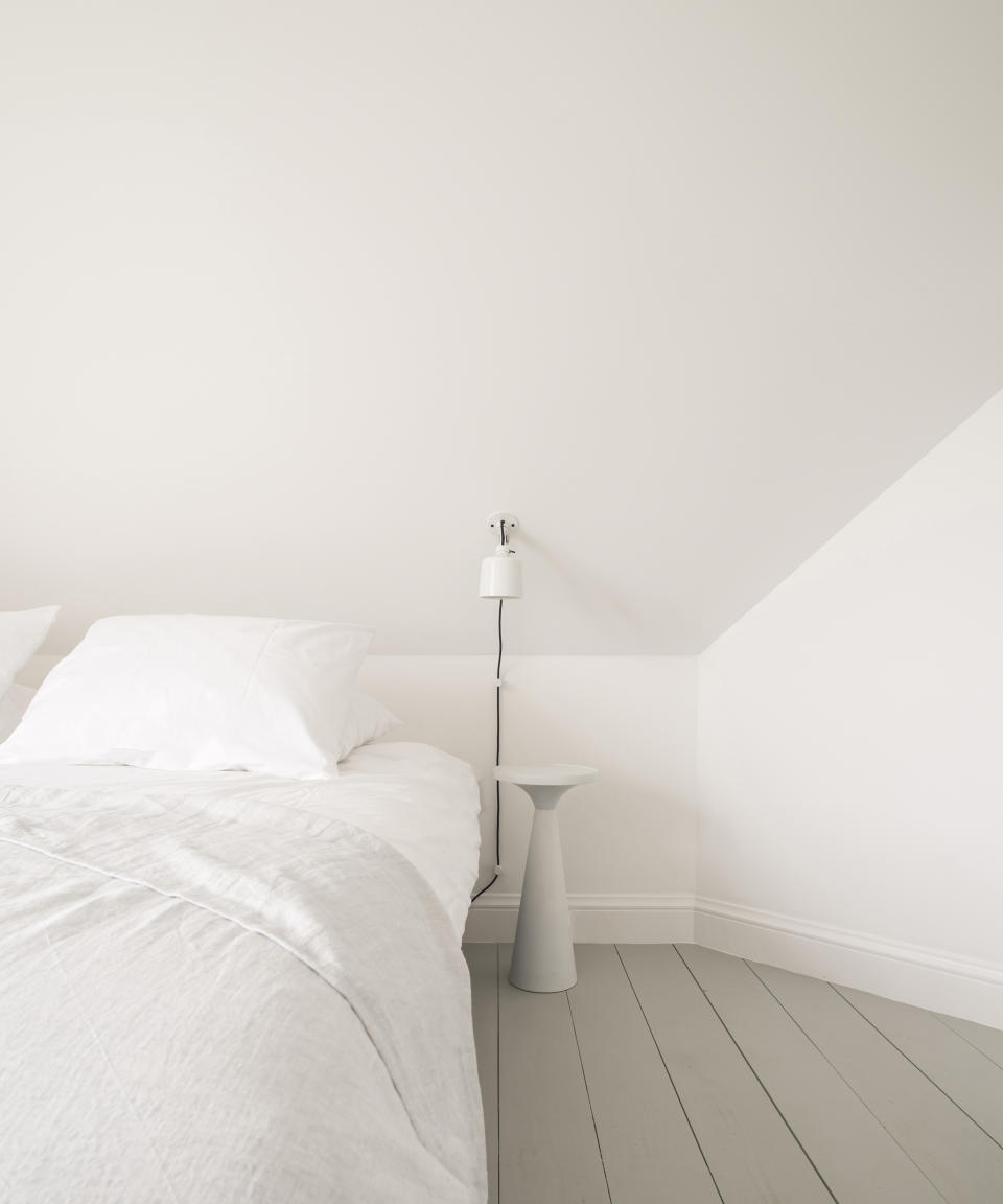 White bedroom with grey floor and crisp white sheets