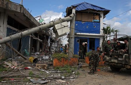 Soldiers stand on guard in front of damaged buildings after government troops cleared the area from pro-Islamic State militant groups inside a war-torn area in Bangolo town, Marawi City, southern Philippines October 23, 2017. REUTERS/Romeo Ranoco