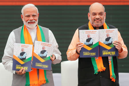 Indian Prime Minister Narendra Modi and chief of India's ruling Bharatiya Janata Party (BJP) Amit Shah, display copies of their party's election manifesto for the April/May general election in New Delhi, India, April 8, 2019. REUTERS/Adnan Abidi