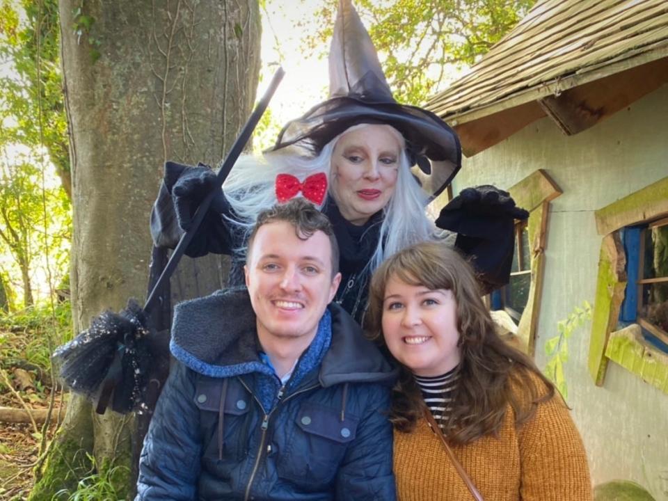 alexis and her partner posing with a witch at a halloween event