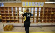 Sabine Standke, 32-year-old postwoman of the German postal and logistics group Deutsche Post, sorts mail at a sorting office in Berlin's Mitte district, December 4, 2013. Deutsche Post, the world's number one postal and logistics group, transported around 18 billion letters in 2012. REUTERS/Fabrizio Bensch (GERMANY - Tags: BUSINESS EMPLOYMENT)