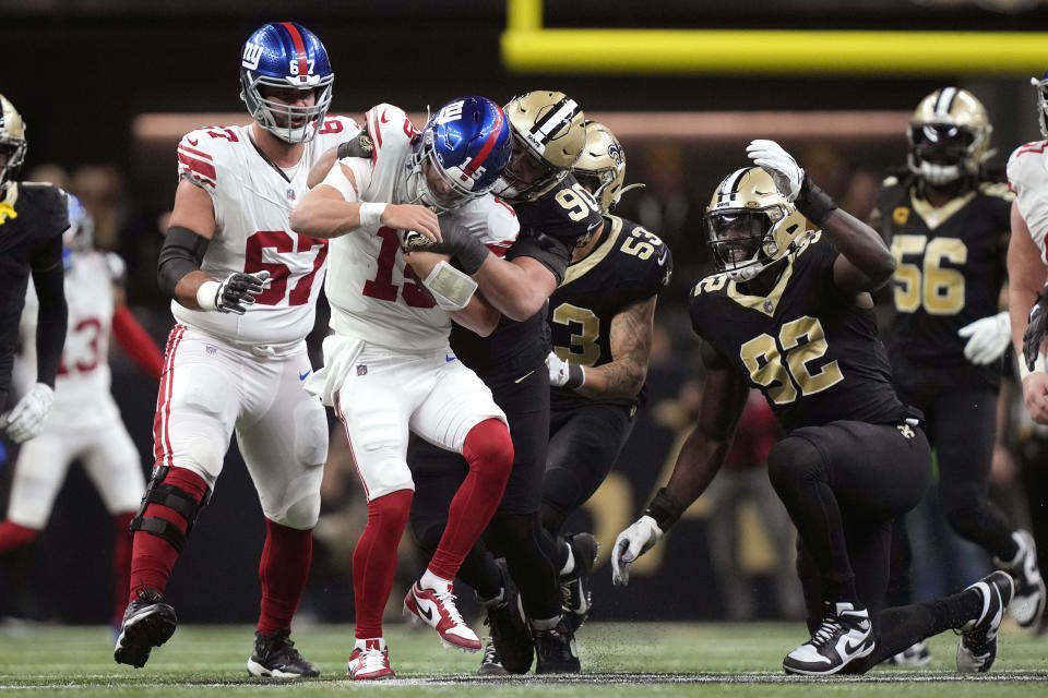 New York Giants quarterback Tommy DeVito (15) is sacked by New Orleans Saints defensive tackle Bryan Bresee (90) for a 10-yard loss during the first half of an NFL football game Sunday, Dec. 17, 2023, in New Orleans. (AP Photo/Gerald Herbert)