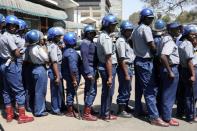 Police officers stand guard during a protest by doctors over the disappearance of the leader of their union in Harare