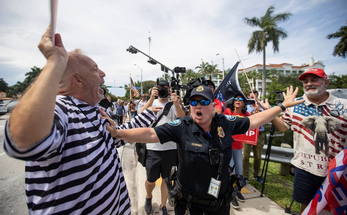 Anti-Trumper Domenic Santana, left, and a pro-Trump supporter, right, are separated by a police officer near the entrance of Trump National Doral Miami on Monday, June 12, 2023, in Doral, Fla. MATIAS J. OCNER/mocner@miamiherald.com