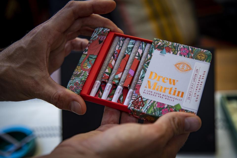 A colorful box containing four pre-rolled joints.