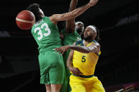 Australia's Patty Mills (5) passes the ball around Nigeria's Jordan Nwora (33) during a men's basketball preliminary round game at the 2020 Summer Olympics, Sunday, July 25, 2021, in Saitama, Japan. (AP Photo/Eric Gay)