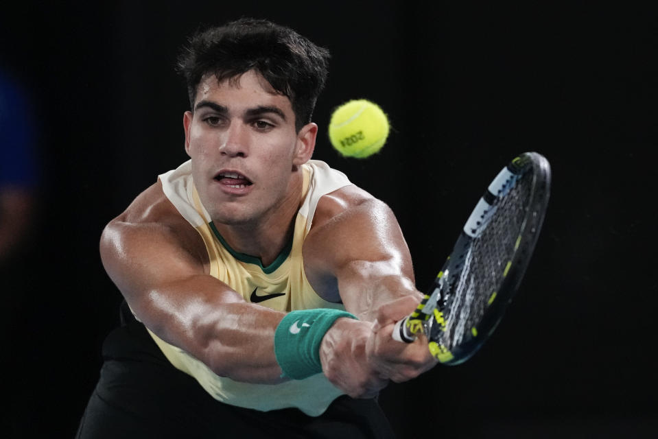 Carlos Alcaraz of Spain plays a backhand return to Richard Gasquet of France during their first round match at the Australian Open tennis championships at Melbourne Park, Melbourne, Australia, Tuesday, Jan. 16, 2024. (AP Photo/Andy Wong)