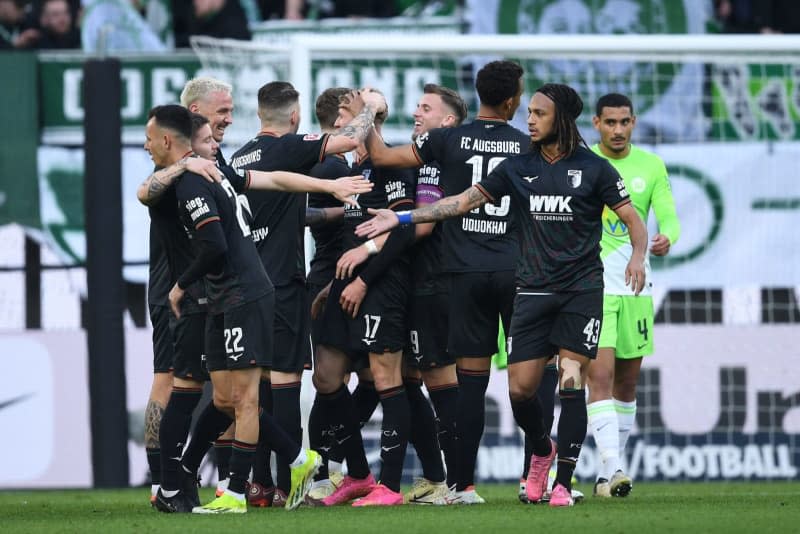 Augsburg's Kristijan Jakic (C) celebrates scoring his side's third goal with teammates during the German Bundesliga soccer match between VfL Wolfsburg and FC Augsburg Volkswagen Arena. Swen Pförtner/dpa