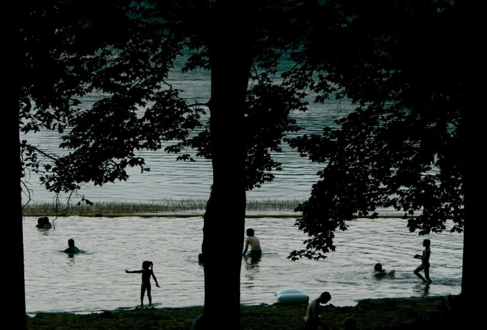 Swimmers frolic in the water at Turkeyfoot Lake on a summer day at Portage Lakes State Park in New Franklin.