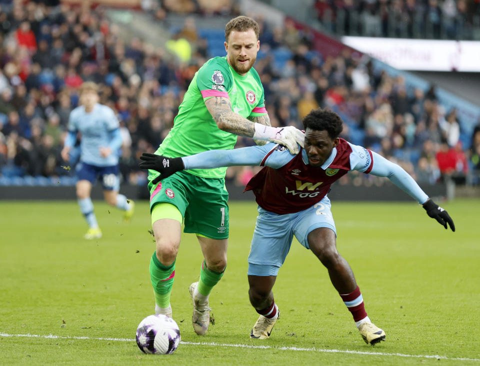 Burnley's David Datro Fofana, right, attempts to take the ball around Brentford goalkeeper Mark Flekken, during the English Premier League soccer match between Burnley and Brentford at Turf Moor, in Burnley, England, Saturday, March 16, 2024. (Richard Sellers/PA via AP)