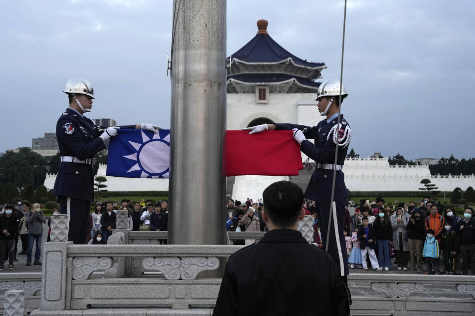 Members of an honour guard lower the national flag during the daily flag ceremony on Liberty Square near the Chiang Kai-shek Memorial Hall in Taipei, Taiwan, Sunday, Jan. 7, 2024. Using military threats, diplomatic pressure, fake news and financial inducements for politicians, China is deploying a broad strategy to influence voters in Taiwan’s elections to pick candidates who favor unification. (AP Photo/Ng Han Guan)