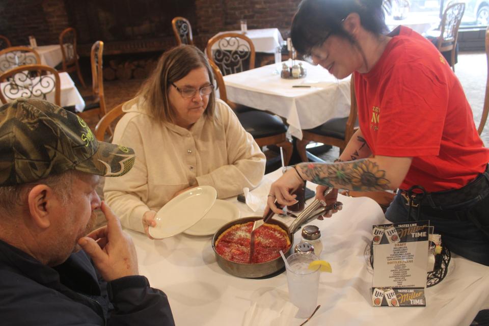 Brie Nelson serves a large Chicago-style deep-dish pizza to Dave and Julie Rudisell on Oct. 20, 2023, at the new Pizzeria Uno in LaPorte inside the Pine Lake Resort and Banquets hotel.