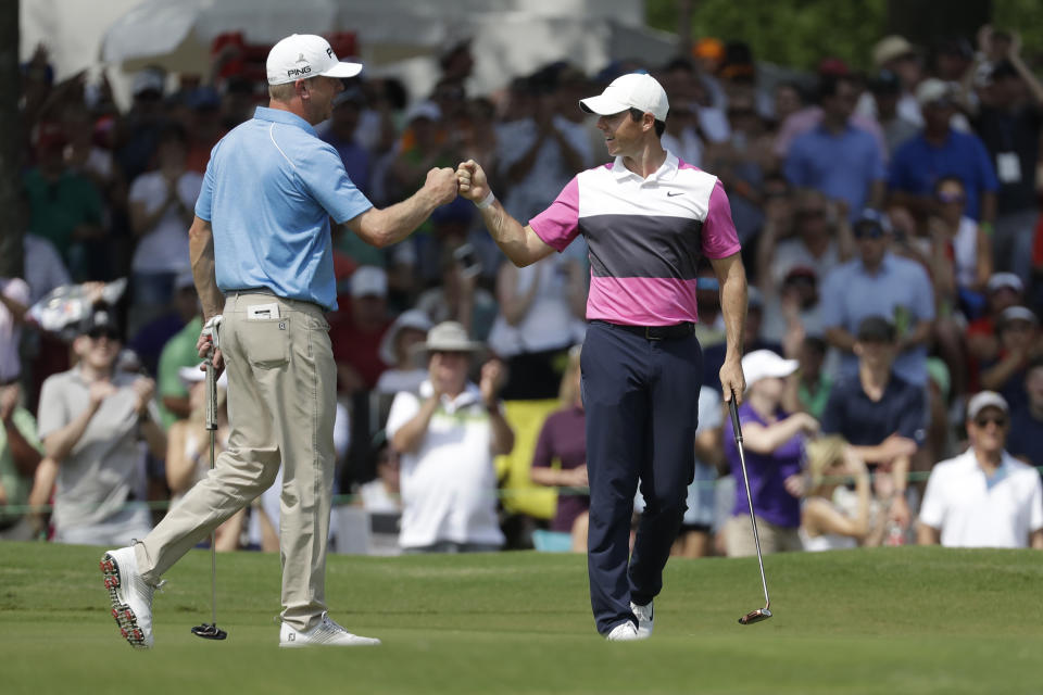 Rory McIlroy, of Northern Ireland, right, is congratulated by playing partner Nate Lashley after McIlroy sank his birdie putt on the 18th green to give him the lead during the third round of the World Golf Championships-FedEx St. Jude Invitational Saturday, July 27, 2019, in Memphis, Tenn. McIlroy finished the day at 12-under par, one stroke ahead of Brooks Kopeka. (AP Photo/Mark Humphrey)