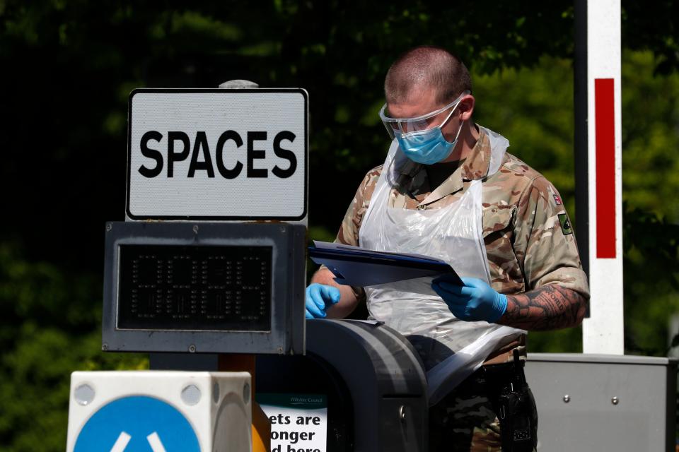 A soldier from the Royal Welsh Regiment consults information on a clipboard at the entrance to a mobile coronavirus COVID-19 testing centre set up in a park and ride site in Salisbury, southern England, on April 26, 2020, during the national lockdown due to the novel coronavirus COVID-19 pandemic. - Britain's health ministry on Saturday said 813 more people had died after testing positive for COVID-19 in hospital, taking the death toll to 20,319. (Photo by Adrian DENNIS / AFP) (Photo by ADRIAN DENNIS/AFP via Getty Images)