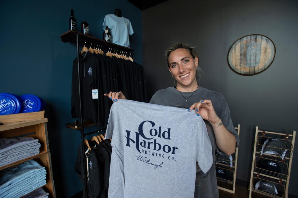 Emily Tynan, marketing director at Cold Harbor Brewing Co., displays a piece of merchandise that's available for sale, Aug. 2, 2023.