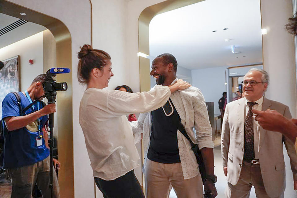 French journalist Olivier Dubois, center, is greeted by his colleague Anne-Fleur Lespiaut at the airport in Niamey, Niger, Monday March 20, 2023. Dubois, who was abducted almost two years ago, was released alongside American aid worker Jeffery Woodke who was held by Islamic extremists in West Africa for more than six years. The two men were the highest-profile foreigners known to be held in the region, and their release was the largest since a French woman and two Italian men were freed together in Mali back in Oct. 2020. (AP Photo/Judith Besnard)