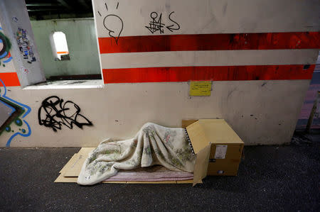 A man sleeps on a street in the night nearby Miyashita park in Tokyo, Japan, March 7, 2017. REUTERS/Kim Kyung-Hoon