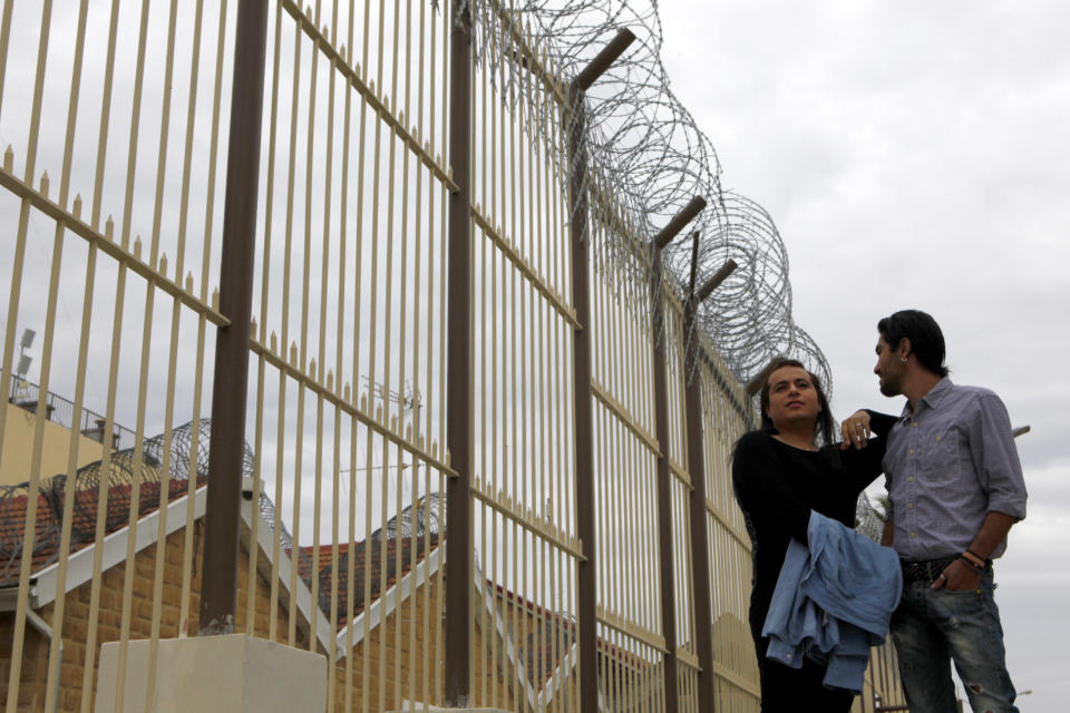 Cypriot Kevork Tontian, right, and Brazilian Wemson Gabral da Costa walk inside the Cyprus' prisons in capital Nicosia, Cyprus, Thursday, Jan. 16, 2020. The 34 year-old Tontian says that after being released from Cyprus' central prisons complex two-years ago, his longing for Wemson and his family's rejection because of his homosexuality, drove him to break the law just so he could rejoin the 30-year old Brazilian national back in prison. (AP Photo/Petros Karadjias)