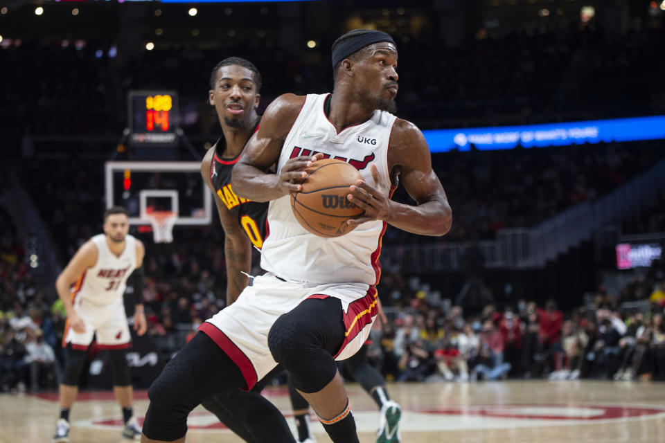 Miami Heat forward Jimmy Butler, right, spins past Atlanta Hawks guard Delon Wright (0) during the second half of an NBA basketball game Friday, Jan. 21, 2022, in Atlanta. (AP Photo/Hakim Wright Sr.)