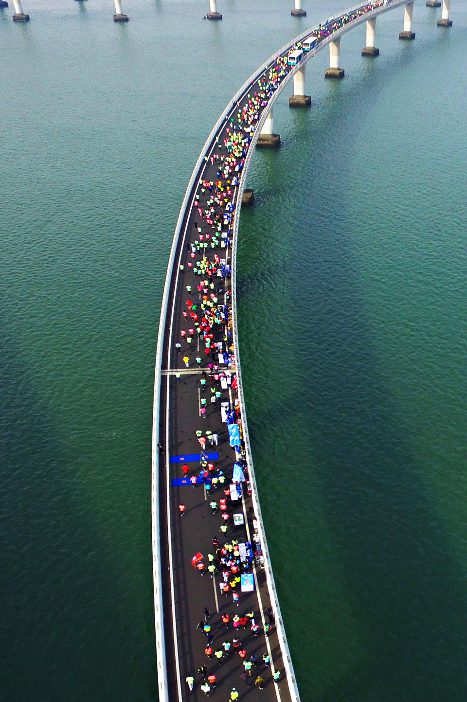 <p>This photo taken on November 19, 2017 shows participants crossing the Jiaozhou Bay Bridge as they compete in the 2017 Qingdao International Marathon on the Sea in Qingdao in China’s eastern Shandong province. (STR/AFP/Getty Images) </p>