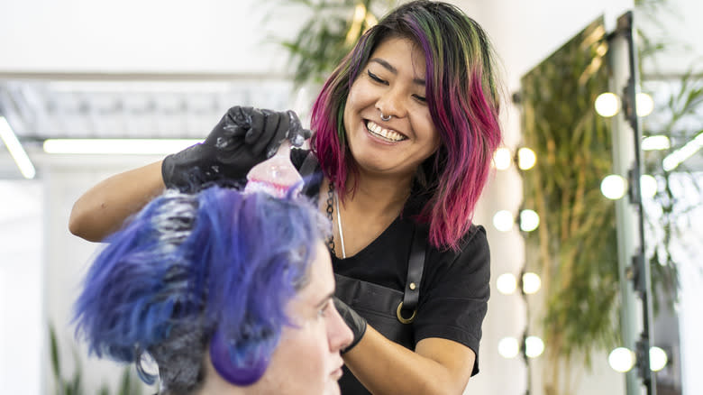 woman dyeing hair at salon 