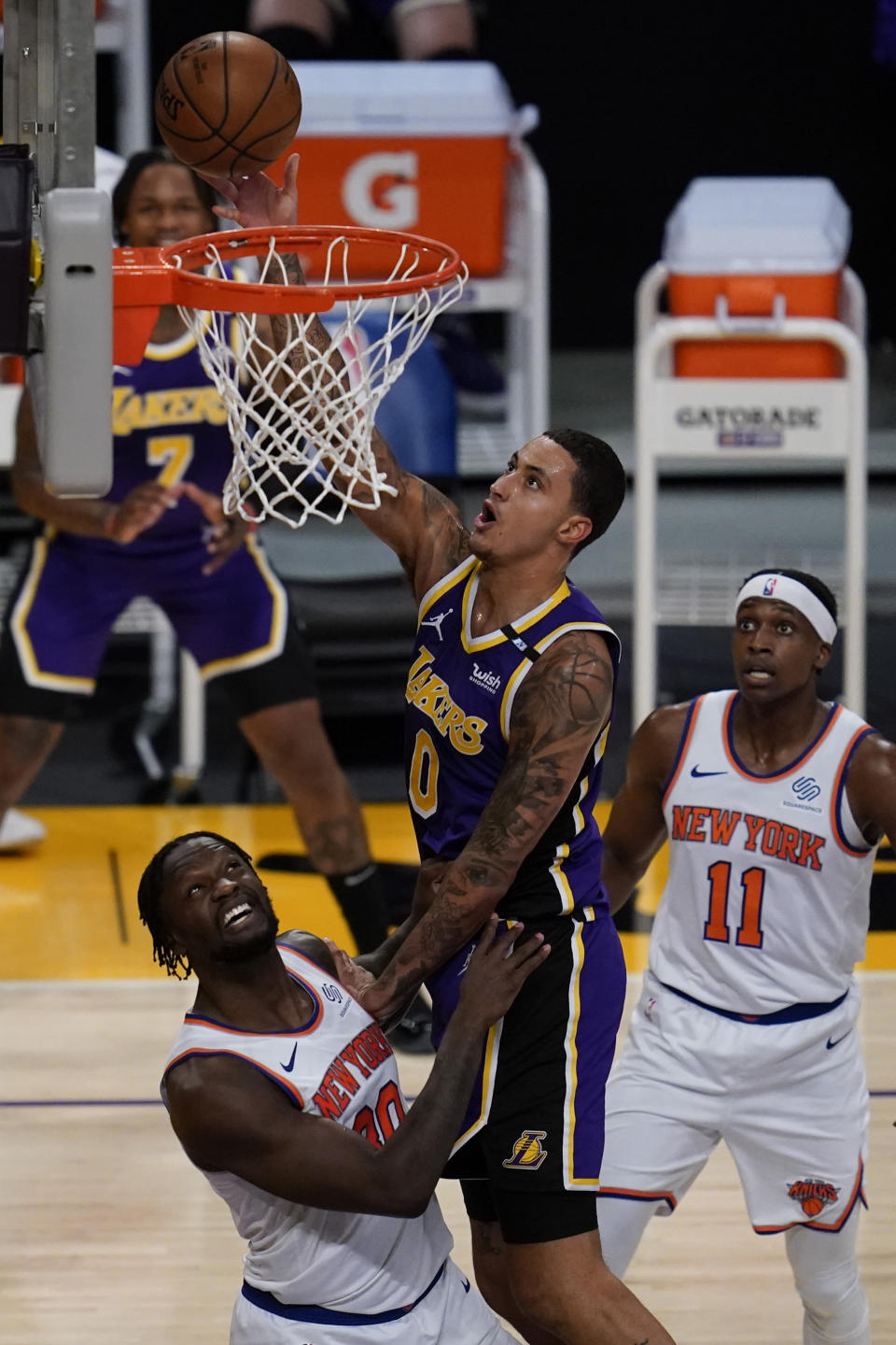 Los Angeles Lakers forward Kyle Kuzma (0) shoots against New York Knicks forward Julius Randle (30) during the second quarter of a basketball game Tuesday, May 11, 2021, in Los Angeles. (AP Photo/Ashley Landis)