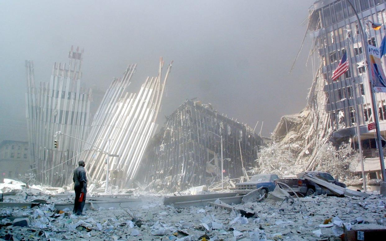 A man stands in the rubble, and calls out asking if anyone needs help, after the collapse of the first of the twin towers of the World Trade Center Tower in lower Manhattan, New York - DOUG KANTER /AFP