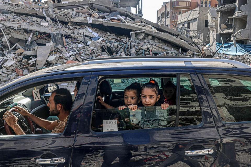 PHOTO: Palestinians drive amid the rubble of buildings destroyed in an Israeli air strike in Rafah, on the southern Gaza Strip on Oct. 12, 2023. (Said Khatib/AFP via Getty Images)