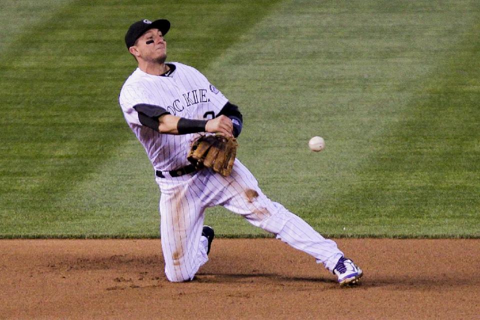 Colorado Rockies' Troy Tulowitzki throws San Francisco Giants' Brandon Belt out at second during the fourth inning of a baseball game, Tuesday, April 22, 2014, in Denver. (AP Photo/Barry Gutierrez)