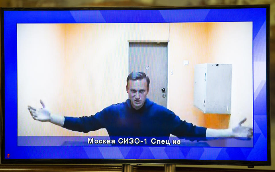 Russian opposition leader Alexei Navalny appears on a TV screen during a live session with the court during a hearing of his appeal in a court in Moscow, Russia, Thursday, Jan. 28, 2021. Navalny was jailed soon after arriving to Moscow after authorities accused him of violating of the terms of his 2014 fraud conviction. A court on Thursday is to hear an appeal on the ruling to remand him into custody. Next week, another court will decide whether to send him to prison for several years for the alleged violations. (AP Photo/Alexander Zemlianichenko)