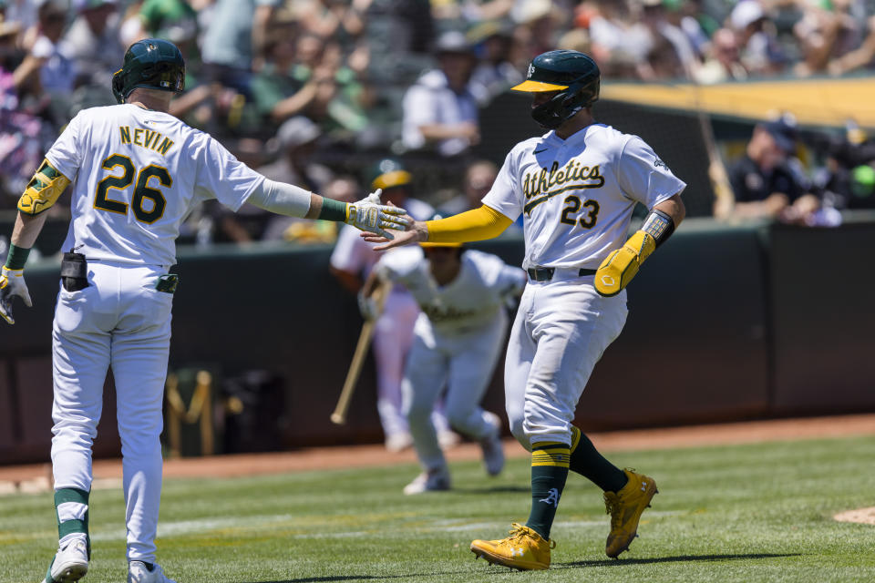 Oakland Athletics' Shea Langeliers (23) is congratulated by Tyler Nevin (26) after he scored against the Baltimore Orioles during the second inning of a baseball game Saturday, July 6, 2024, in Oakland, Calif. (AP Photo/John Hefti)