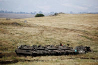 FILE PHOTO: Israeli soldiers stand on tanks near the Israeli side of the border with Syria in the Israeli-occupied Golan Heights, Israel May 9, 2018. REUTERS/Amir Cohen/File Photo