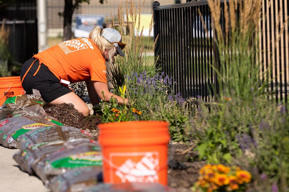 Jennifer Morford plants flowers in the front garden at Freedom Landing in Salt Lake City on Wednesday, July 12, 2023. The Home Depot Foundation, in partnership with the Housing Authority of Salt Lake City, renovated two permanent housing facilities on Wednesday meant for homeless veterans, individuals with disabilities and the chronically homeless. | Megan Nielsen, Deseret News