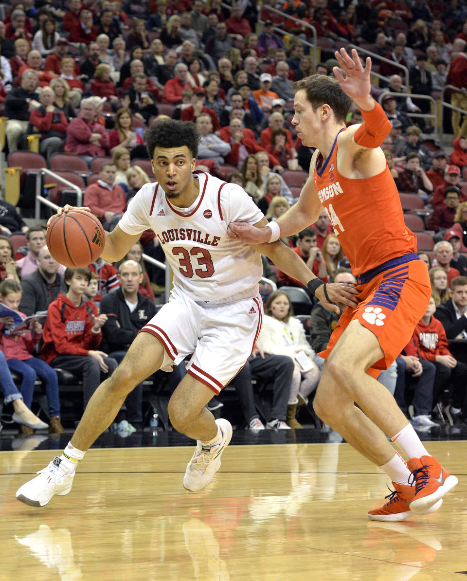 FILE - In this Feb. 16, 2019, file photo, Louisville forward Jordan Nwora (33) attempts to drive past the defense of Clemson forward Elijah Thomas (14) during the second half of an NCAA college basketball game in Louisville, Ky. The return of forwards Jordan Nwora and Steven Enoch could make the Cardinals a top-10 team heading into next season. (AP Photo/Timothy D. Easley, File)