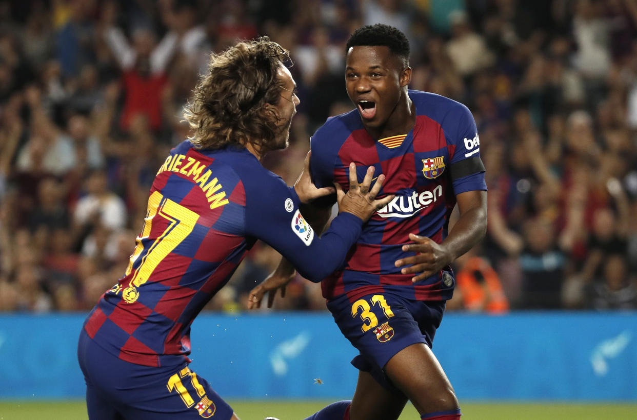 Barcelona's Ansu Fati, right, celebrates with teammate Barcelona's Antoine Griezmann after scoring the opening goal during the Spanish La Liga soccer match between FC Barcelona and Valencia CF at the Camp Nou stadium in Barcelona, Spain, Saturday, Sep. 14, 2019. (AP Photo/Joan Monfort)