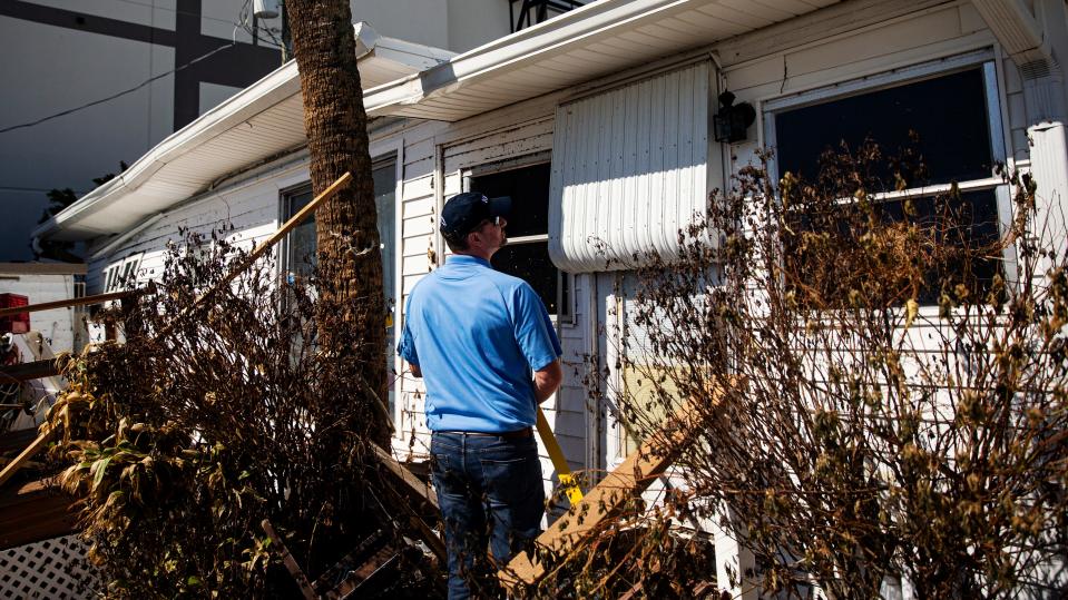 Rodney Wynn, a meteorologist for the National Weather Service assesses Hurricane Ian damage including storm surge heights on homes on San Carlos Island next to Fort Myers Beach on Tuesday, Oct. 4, 2022. 