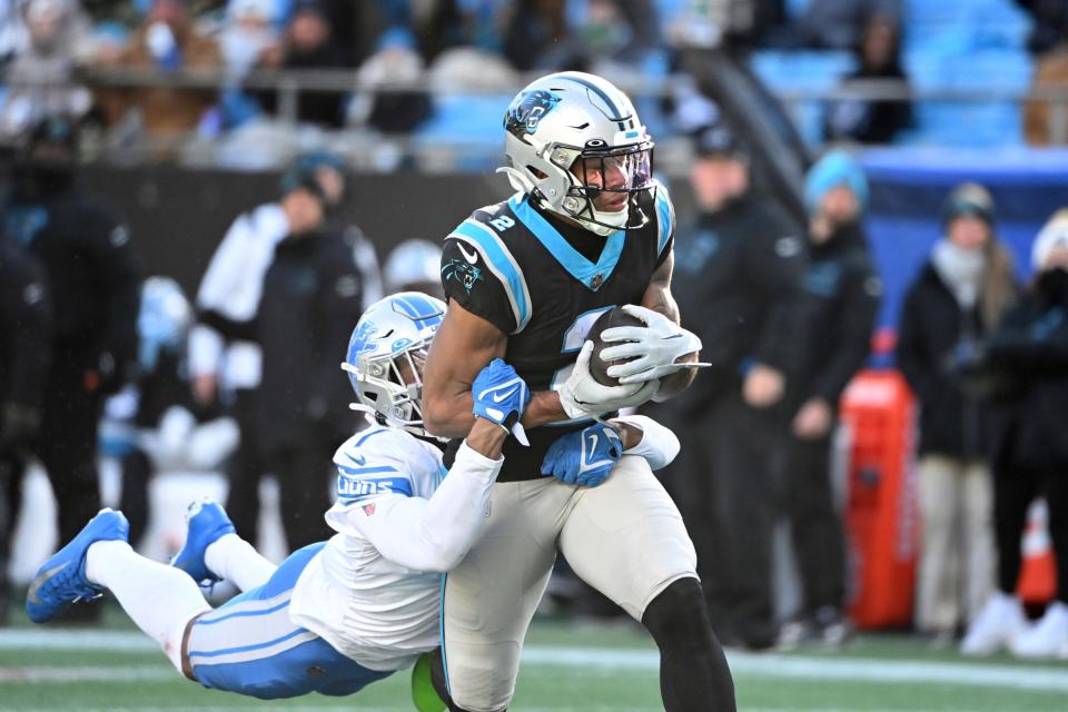 Carolina Panthers wide receiver DJ Moore (2) catches a long pass as Detroit Lions cornerback Jeff Okudah (1) defends in the third quarter at Bank of America Stadium.