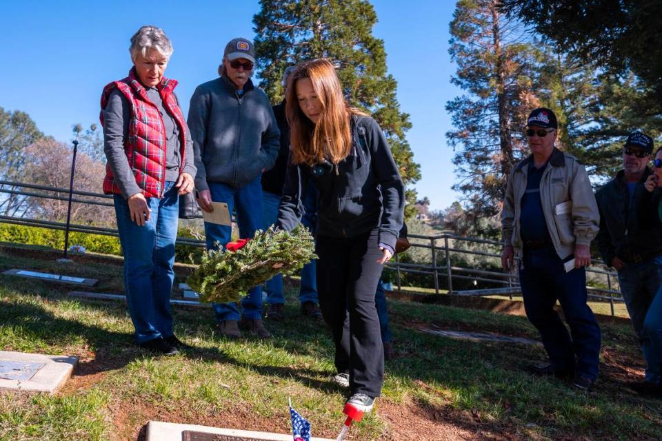 Hadley Jordan, great granddaughter of Barney Gruber, a World War II Marine veteran, lays a wreath at his burial site with her family by her side, following the Remembrance Ceremony at the Newcastle Rocklin Gold Hill Cemetery District earlier this month.