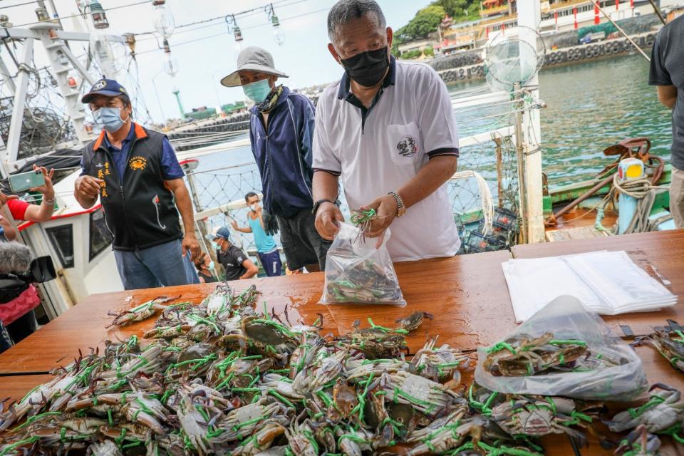 正在活蟹福袋分裝活跳萬里蟹的協會成員與船主。   圖：新北市漁業處提供