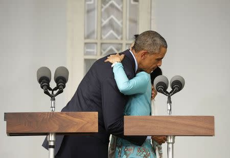 U.S. President Barack Obama and opposition politician Aung San Suu Kyi hug at the end of a press conference after their meeting at her residence in Yangon, November 14, 2014. REUTERS/Kevin Lamarque