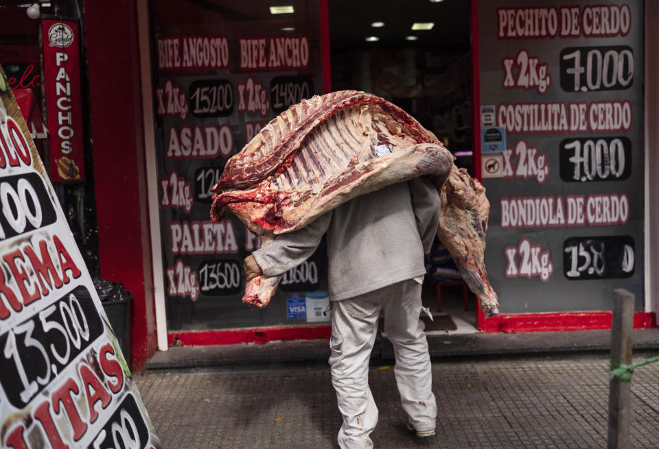 Un vendedor entrega una pieza de carne de res en una carnicería de Buenos Aires, Argentina, el 10 de abril de 2024. El plan de reducción del gasto del presidente, Javier Milei, se ha topado con la resistencia de la población en un país donde la inflación anual supera el 276%. (AP Foto/Rodrigo Abd)