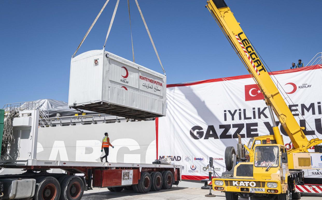 Workers unloading aid from Turkish aid ship to deliver to Gaza